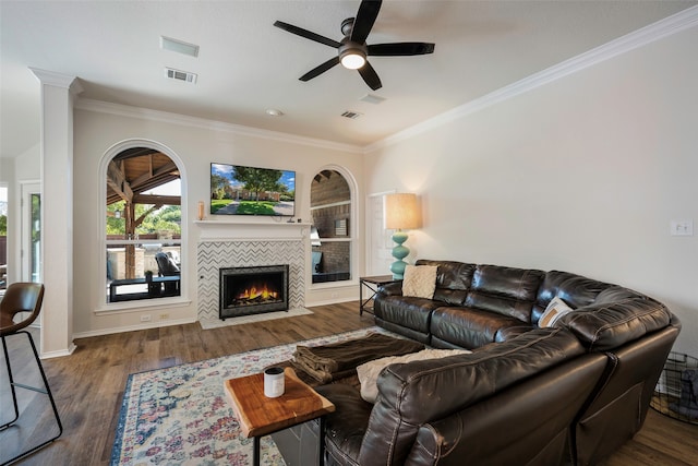 living room with a tile fireplace, ceiling fan, dark hardwood / wood-style flooring, and ornamental molding