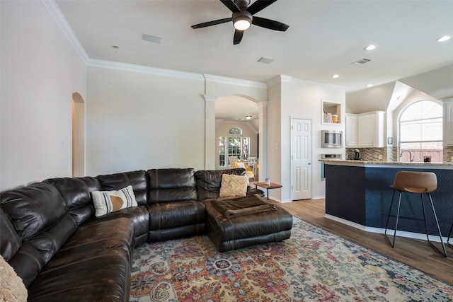 living room with a wealth of natural light, ceiling fan, and dark hardwood / wood-style flooring