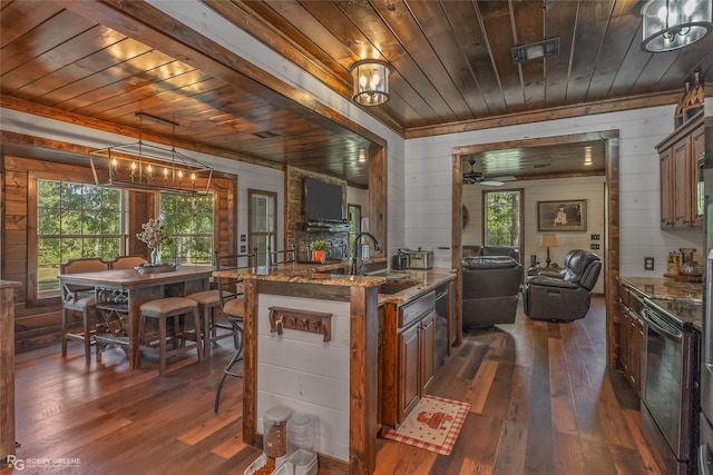 kitchen featuring wood ceiling, hanging light fixtures, wood walls, dark hardwood / wood-style floors, and light stone countertops