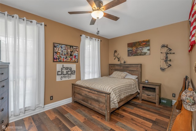 bedroom featuring ceiling fan, dark hardwood / wood-style floors, and multiple windows