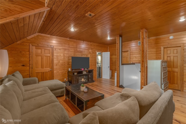 living room with lofted ceiling, light hardwood / wood-style floors, wood walls, and wooden ceiling