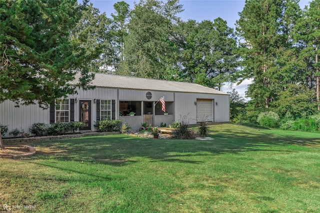 back of house featuring a lawn and a garage