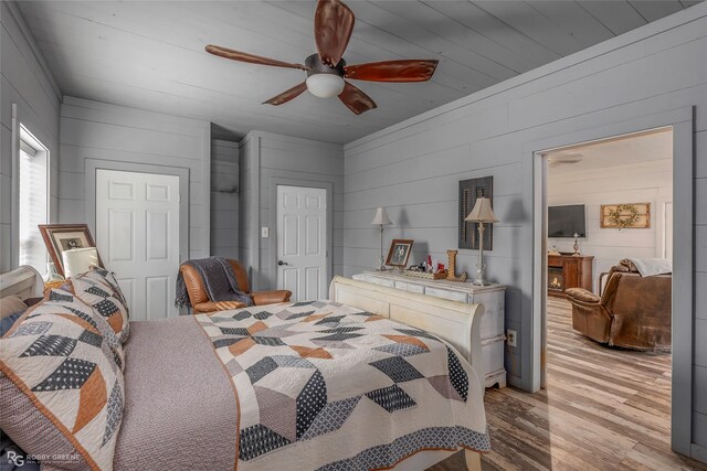9321 Mccain Rd, Shreveport, LA 71107 - bedroom featuring ceiling fan, wood walls, and light wood-style floors