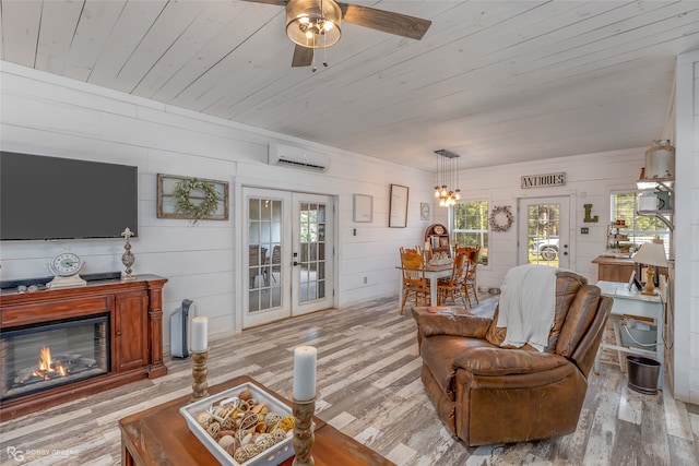 living room featuring ceiling fan, wood ceiling, wooden walls, light hardwood / wood-style floors, and an AC wall unit