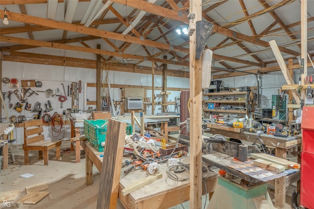 miscellaneous room featuring concrete flooring, vaulted ceiling, and a workshop area