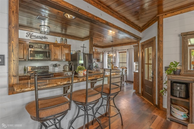 9321 Mccain Rd, Shreveport, LA 71107 - kitchen with brown cabinets, a wealth of natural light, dark wood-type flooring, wood ceiling, and appliances with stainless steel finishes