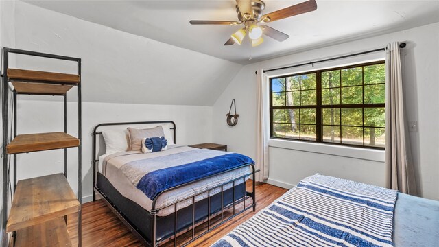 bedroom with ceiling fan, vaulted ceiling, and dark wood-type flooring