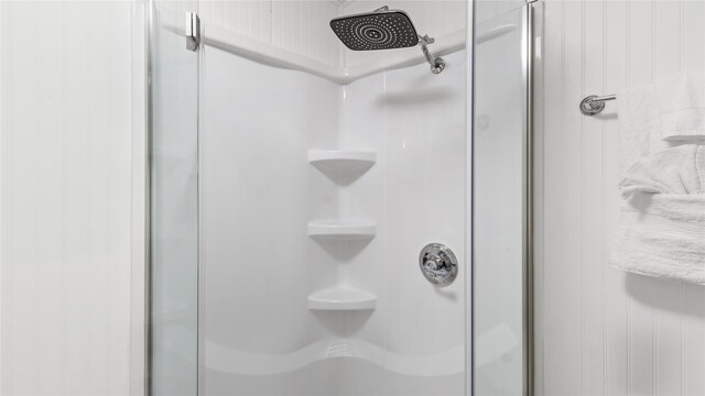 interior details with a shower with door