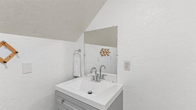 bathroom with lofted ceiling and vanity