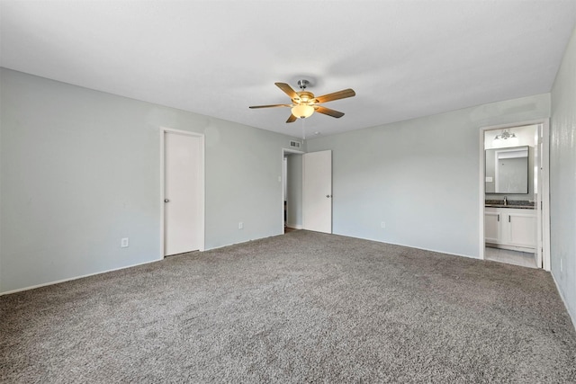 unfurnished bedroom with ceiling fan, ensuite bath, sink, and carpet floors