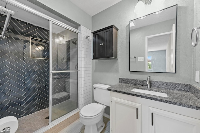 bathroom with vanity, an enclosed shower, and toilet