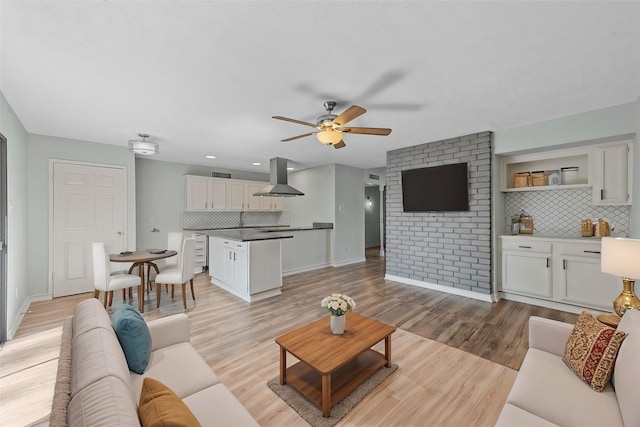 living room featuring ceiling fan and light hardwood / wood-style floors