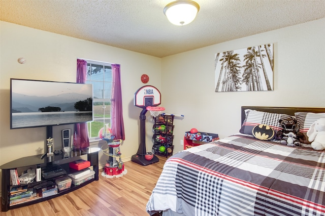 bedroom with wood-type flooring and a textured ceiling