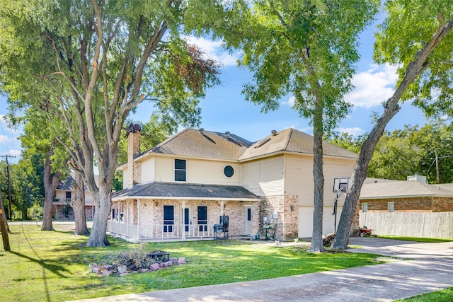 view of front of home featuring a garage, a front lawn, and covered porch