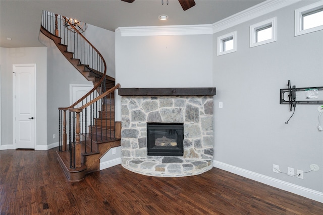 living room featuring ceiling fan, a fireplace, ornamental molding, and a wealth of natural light