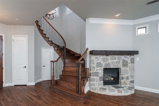 stairway featuring a fireplace, crown molding, and hardwood / wood-style floors