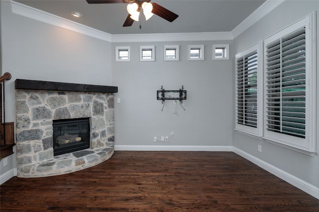 unfurnished living room with dark hardwood / wood-style flooring, ceiling fan, crown molding, and a stone fireplace