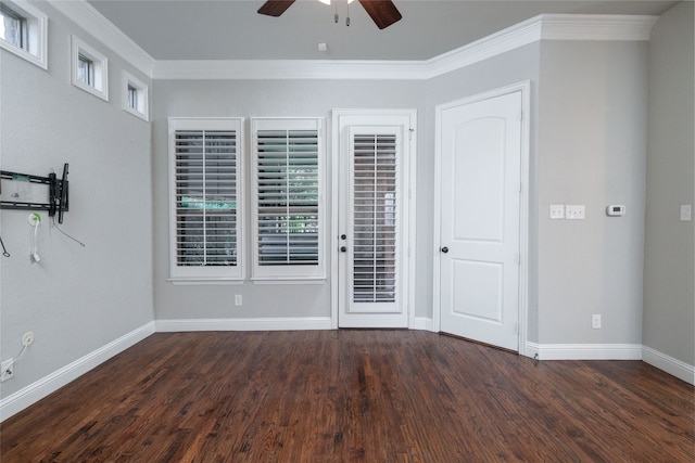 empty room with crown molding, dark wood-type flooring, and ceiling fan