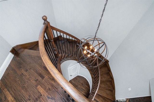 staircase with an inviting chandelier and hardwood / wood-style flooring