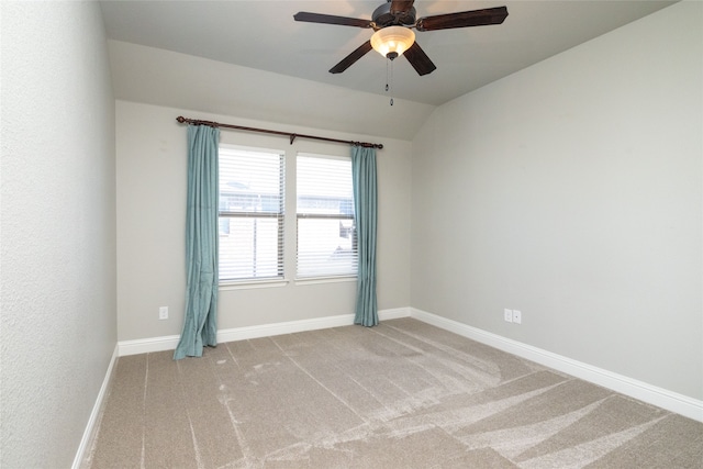 spare room with carpet, vaulted ceiling, and ceiling fan