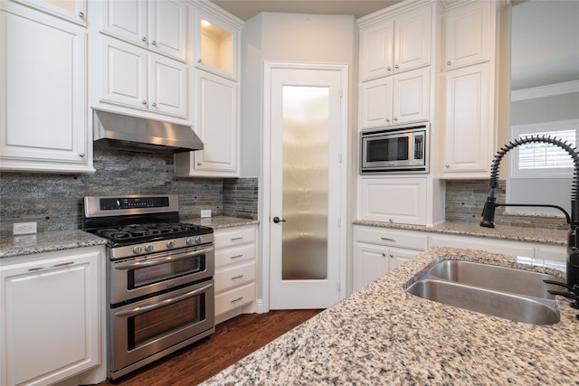 kitchen with ornamental molding, stainless steel appliances, sink, and white cabinetry