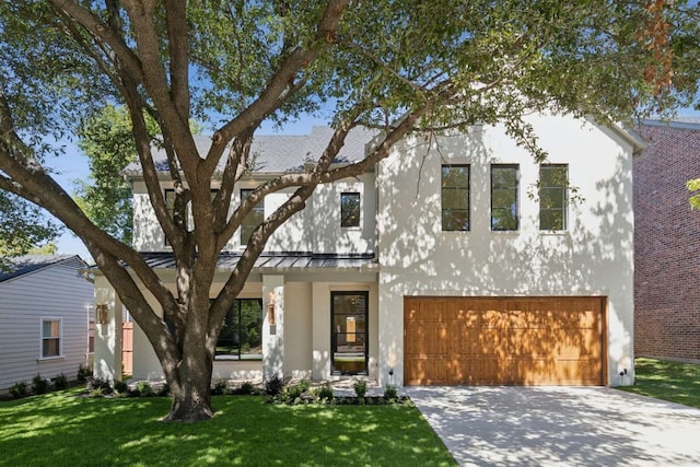 view of front of property featuring a garage and a front lawn