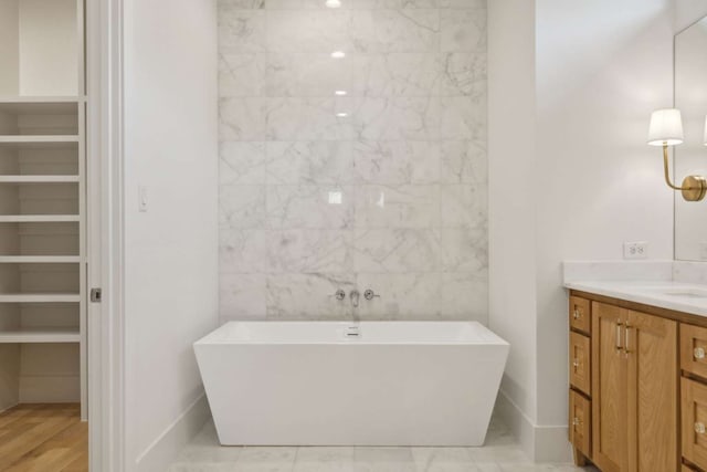 bathroom with a bathing tub, vanity, and hardwood / wood-style flooring