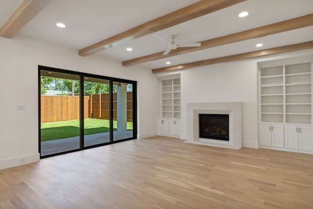 unfurnished living room with ceiling fan, light hardwood / wood-style flooring, built in features, and beam ceiling