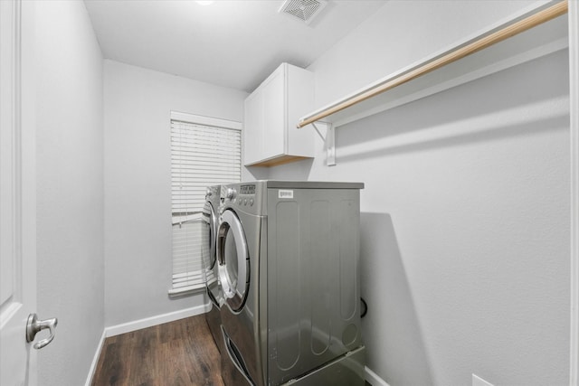 laundry area featuring dark hardwood / wood-style flooring, cabinets, and washer and clothes dryer