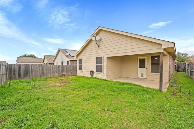 rear view of house with a patio and a yard