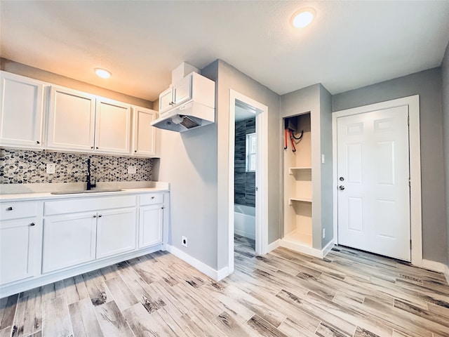 kitchen featuring light hardwood / wood-style flooring, white cabinets, and sink