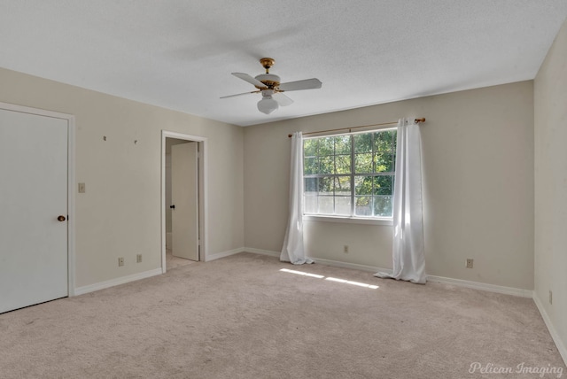 carpeted empty room featuring ceiling fan and a textured ceiling