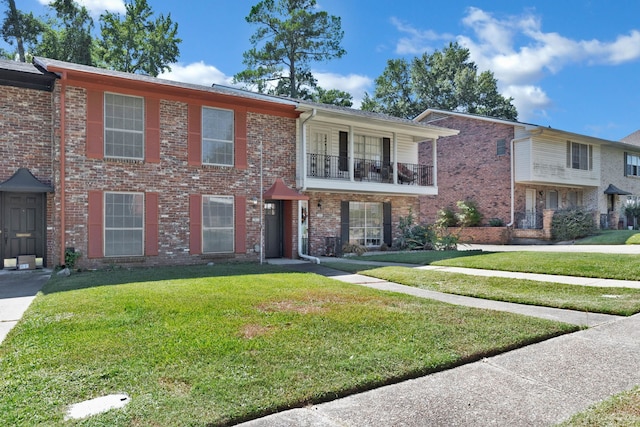 townhome / multi-family property featuring a front yard and a balcony