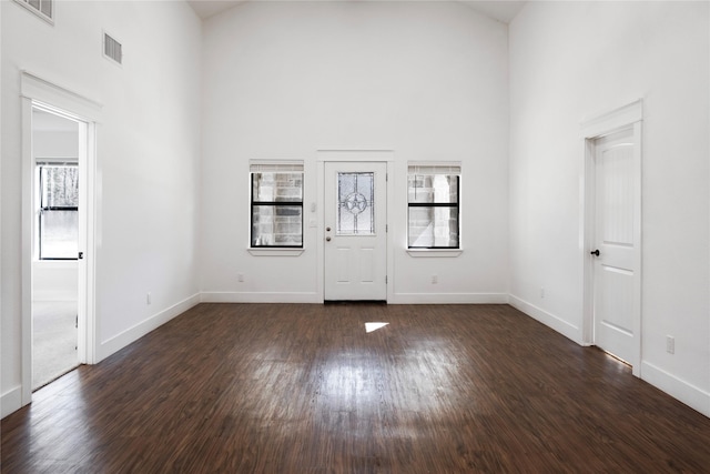 entrance foyer with a towering ceiling and dark hardwood / wood-style floors