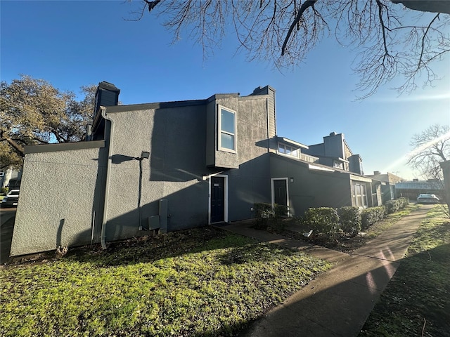 view of property exterior with a chimney and stucco siding