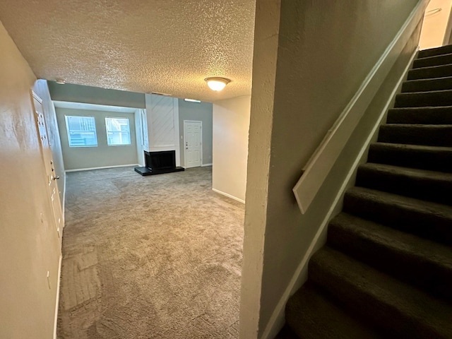 staircase with a textured ceiling and carpet