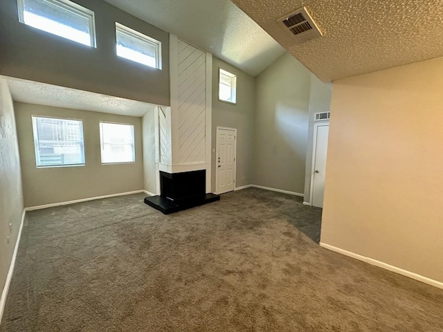 unfurnished room featuring visible vents, baseboards, a textured ceiling, high vaulted ceiling, and dark colored carpet