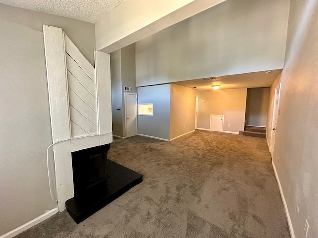 unfurnished living room featuring a textured ceiling, a multi sided fireplace, and carpet flooring