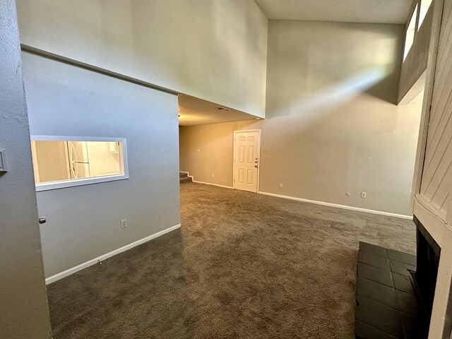 interior space featuring stairway, carpet, baseboards, and a towering ceiling