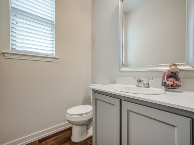 bathroom with vanity, toilet, and hardwood / wood-style flooring