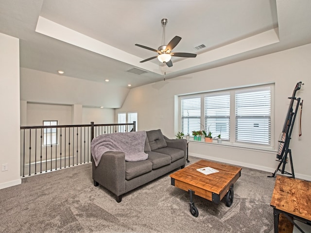 carpeted living room with lofted ceiling, a tray ceiling, and ceiling fan