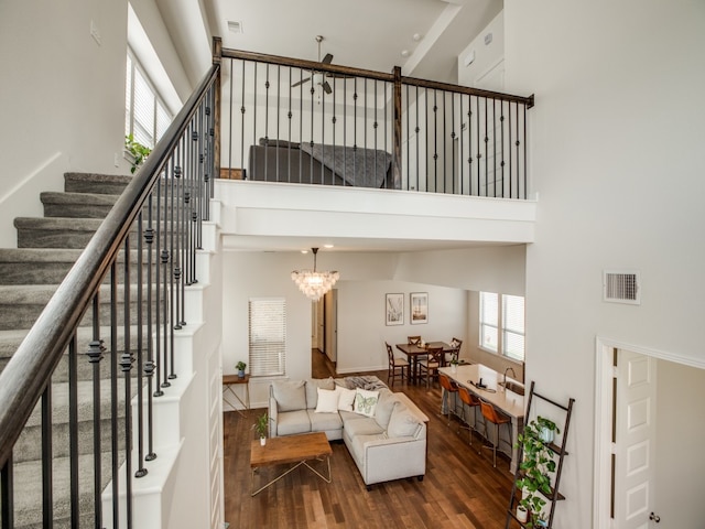 living room with a notable chandelier, a high ceiling, and dark hardwood / wood-style flooring