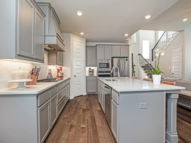 kitchen with gray cabinets, appliances with stainless steel finishes, sink, and dark hardwood / wood-style flooring