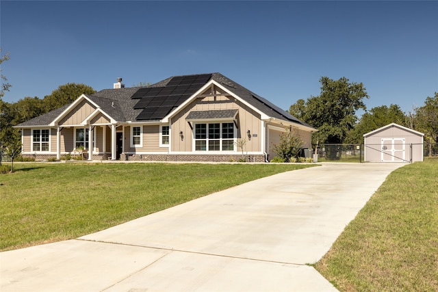 craftsman-style home with a front yard, covered porch, an outdoor structure, solar panels, and a garage