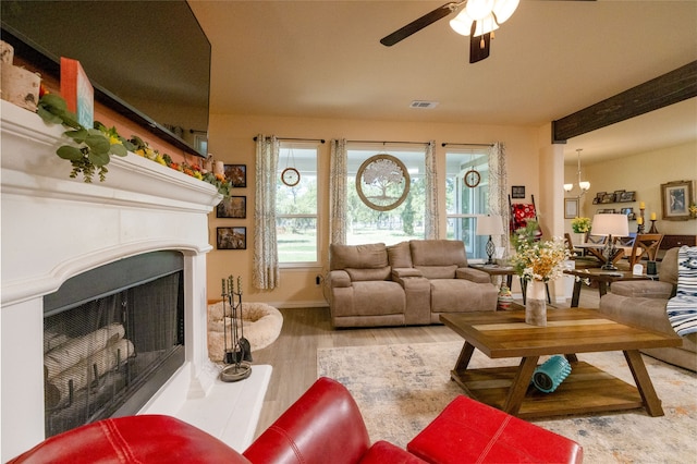 living room featuring ceiling fan, beamed ceiling, and hardwood / wood-style floors