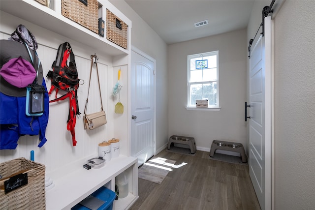 mudroom with dark hardwood / wood-style flooring and a barn door