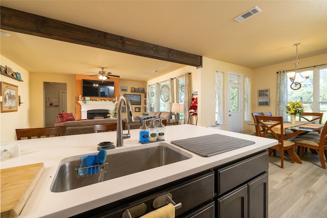 kitchen with ceiling fan with notable chandelier, light hardwood / wood-style floors, plenty of natural light, and decorative light fixtures