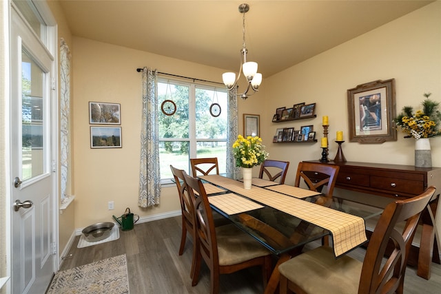 dining room with dark wood-type flooring and a chandelier