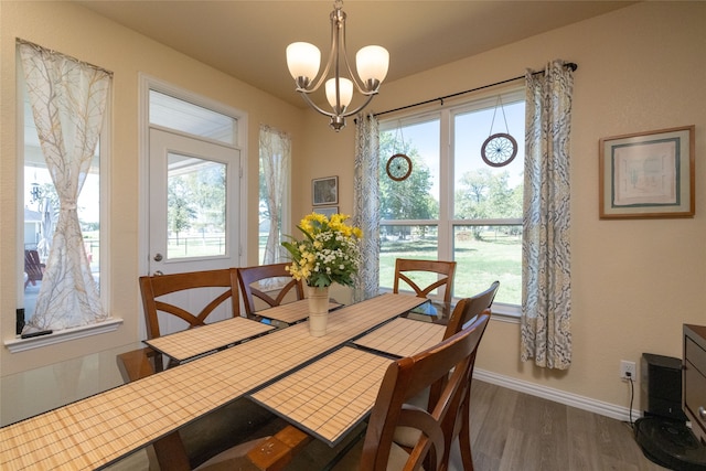 dining room with dark wood-type flooring and a notable chandelier