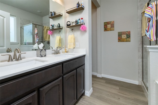 bathroom with hardwood / wood-style flooring, vanity, and a shower with shower door